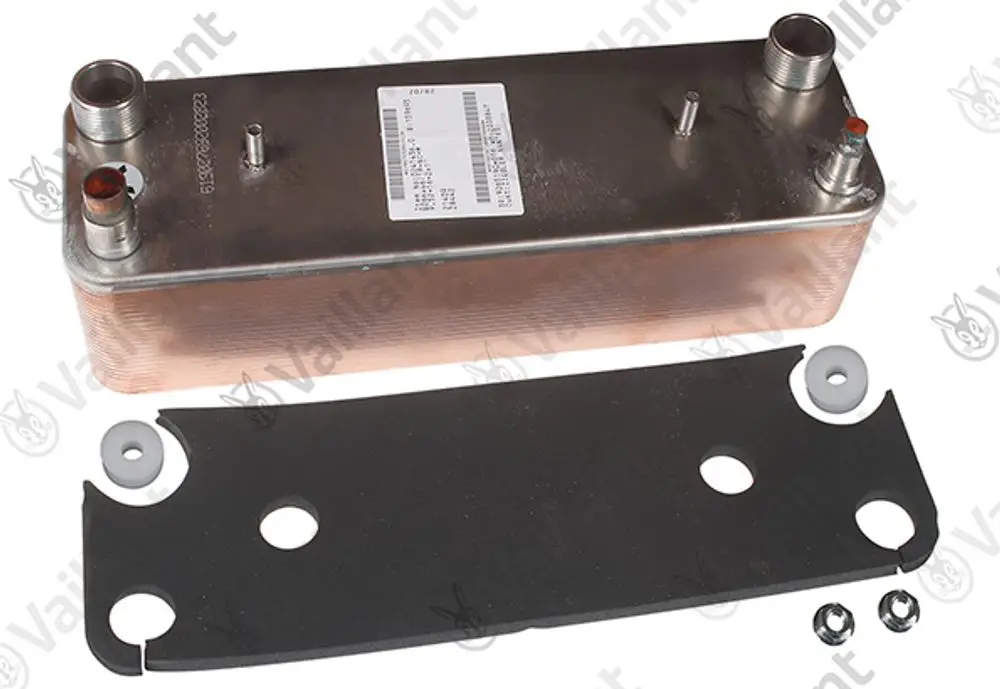 Vaillant Kondensator mit metallischer Oberfläche und Anschlüssen, liegend auf einer schwarzen Dichtung, umgeben von Montageschrauben und Dichtungsringen.